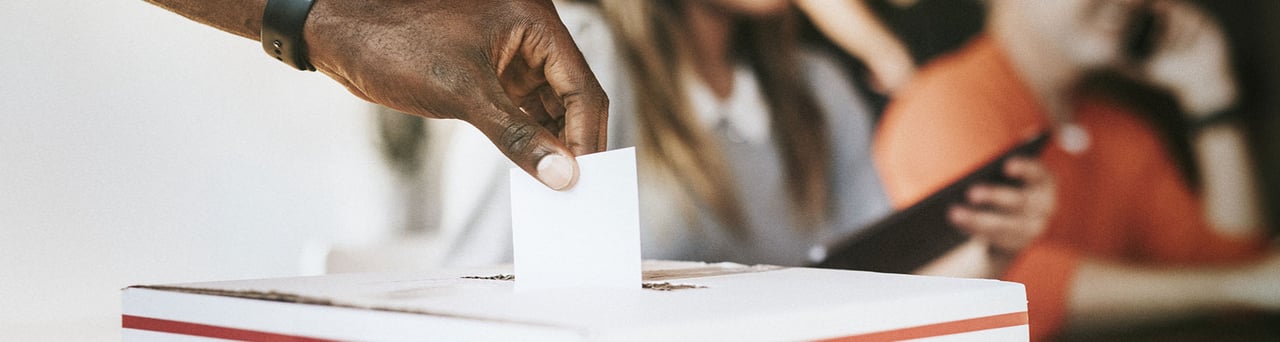 Une personne dépose son bulletin de vote dans une urne
